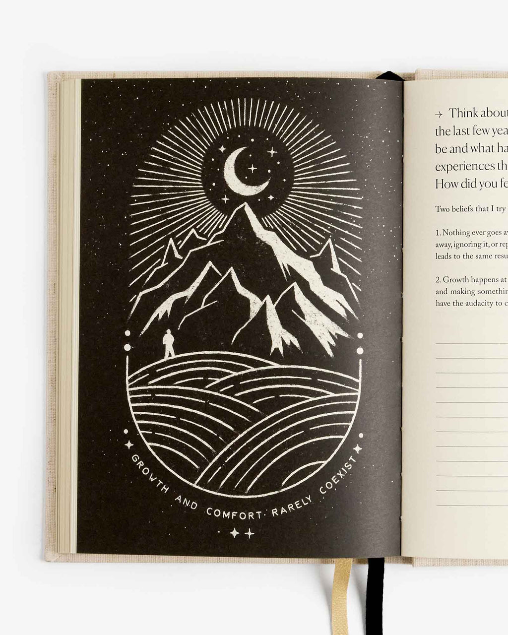 Open book with a black and white illustration of mountains, moon, and person on a white background