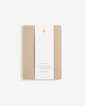 Notebook with beige cover and white back on a light beige background