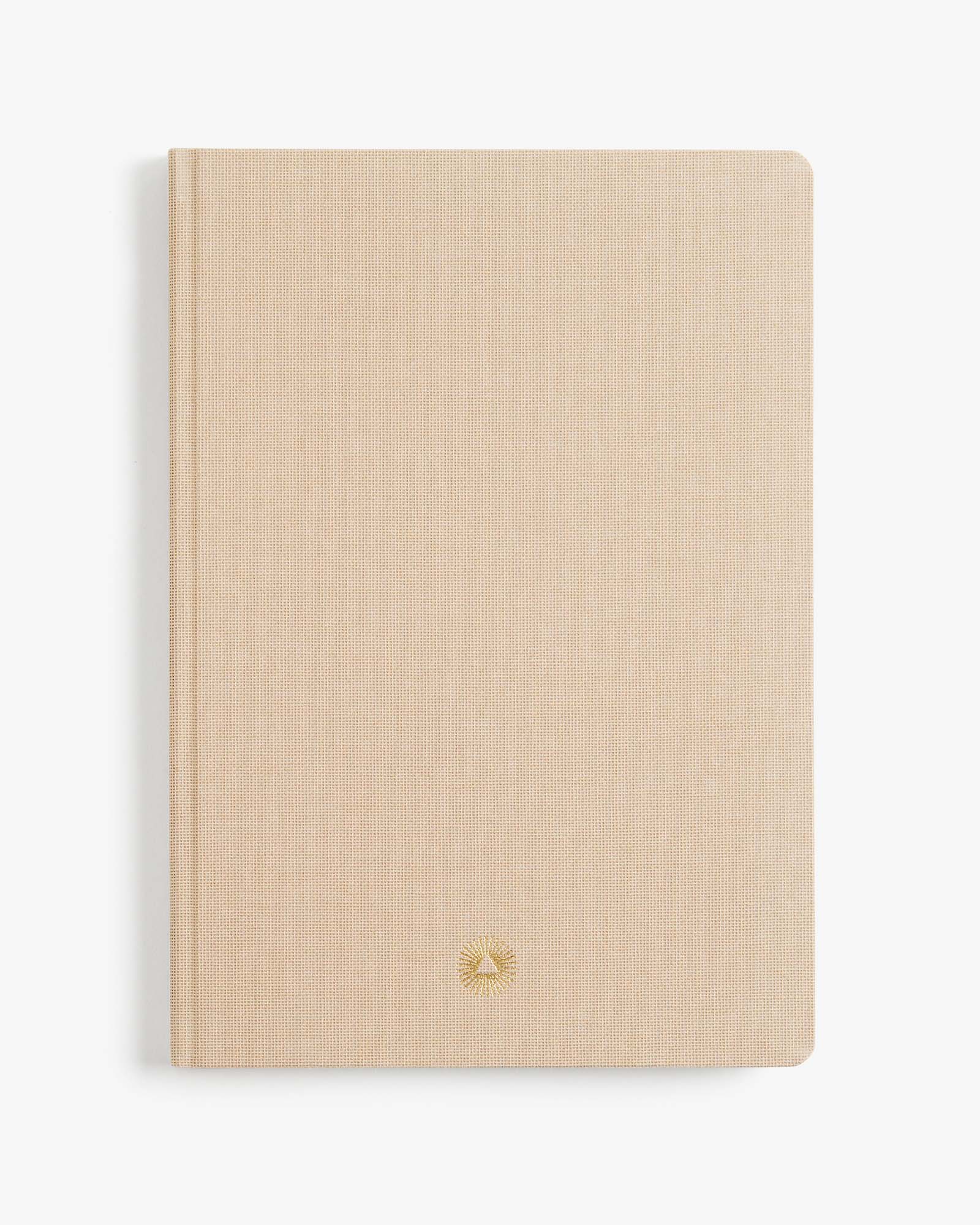 Beige notebook with a gold logo on a white background