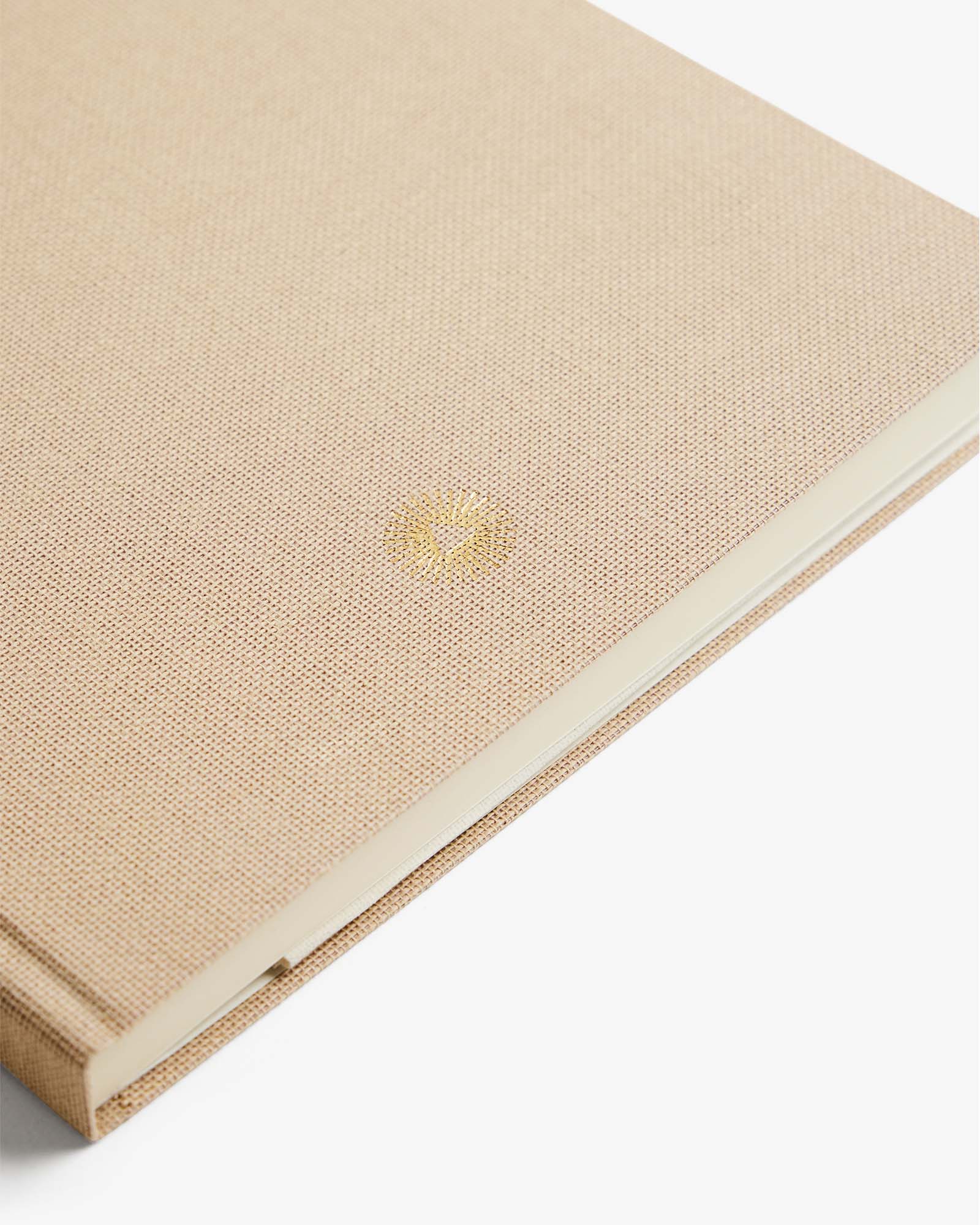 Beige fabric-bound book on a white background