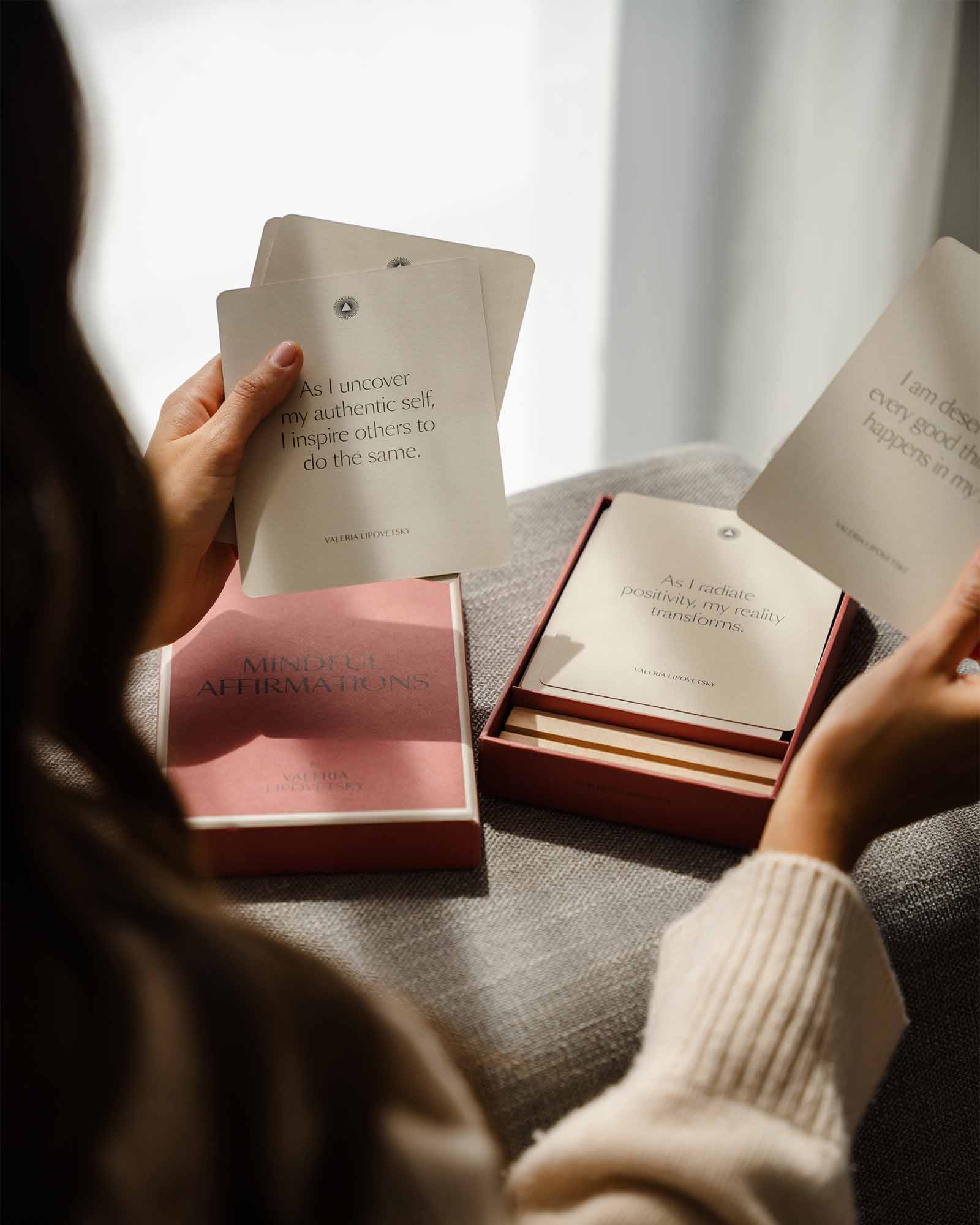 Person holding open books with text on a couch
