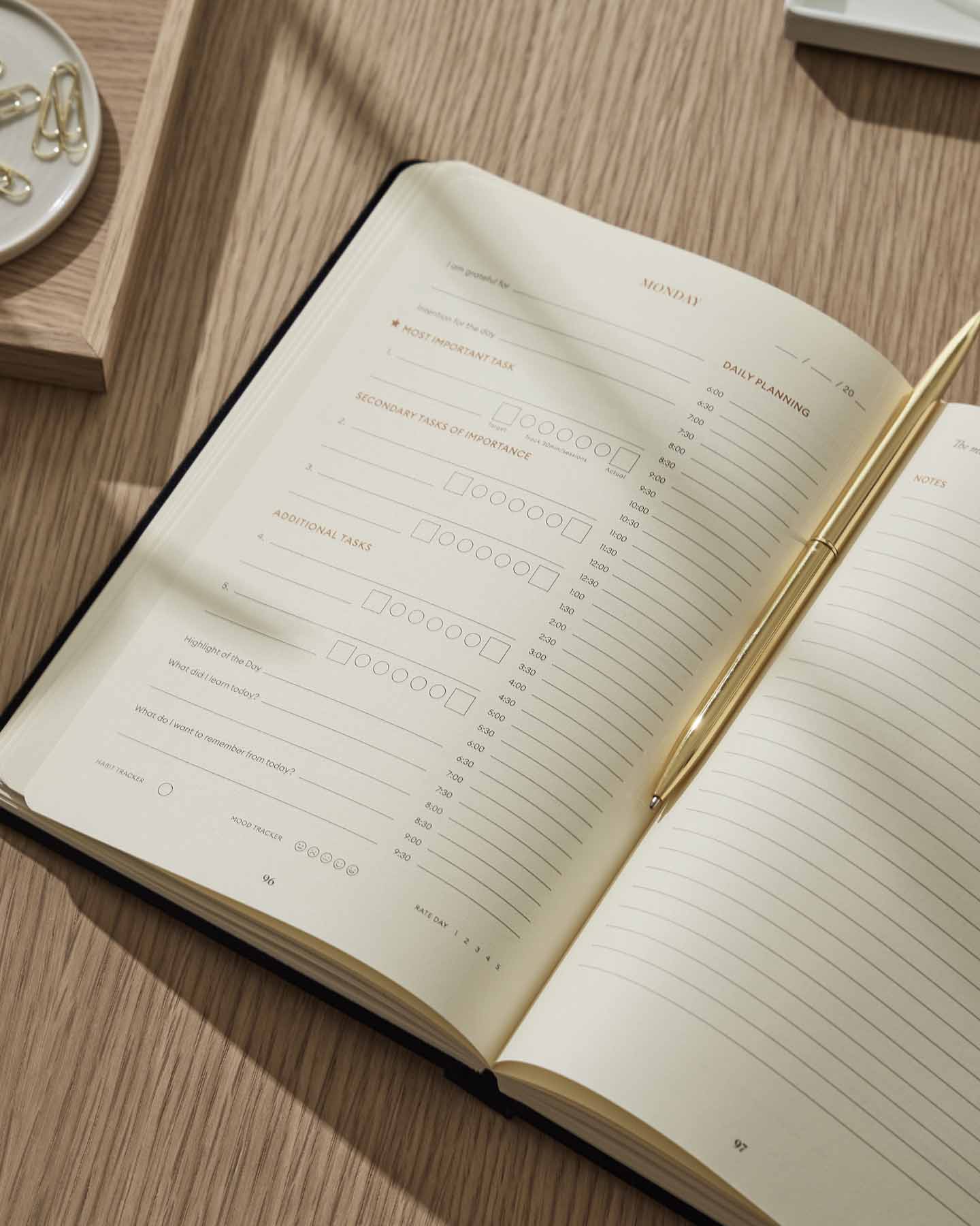Open notebook on a wooden surface with a pen next to it