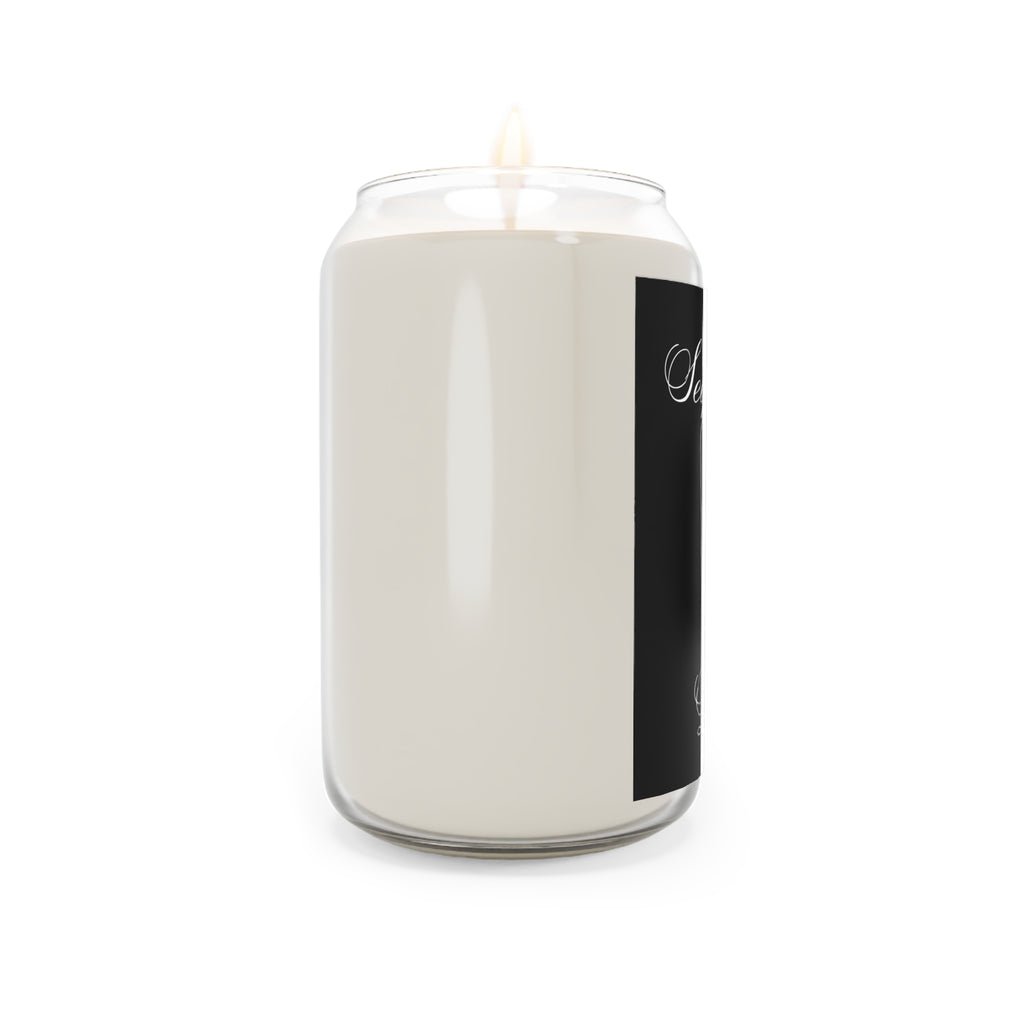 White candle in a glass jar with a black label on a white background