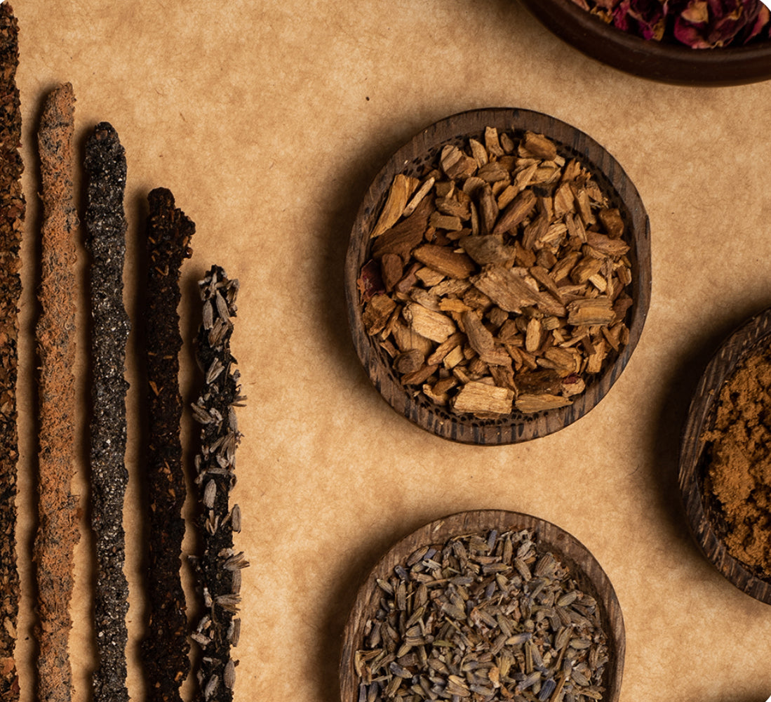 Wooden bowls filled with various dried herbs and spices on a beige background
