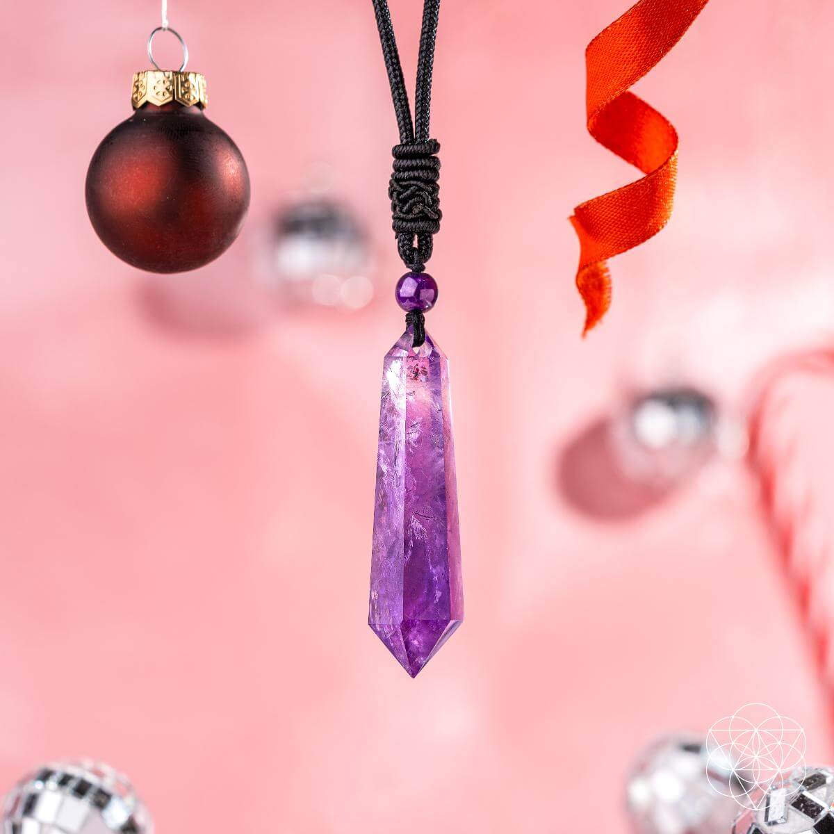 Purple crystal pendant necklace with a pink background