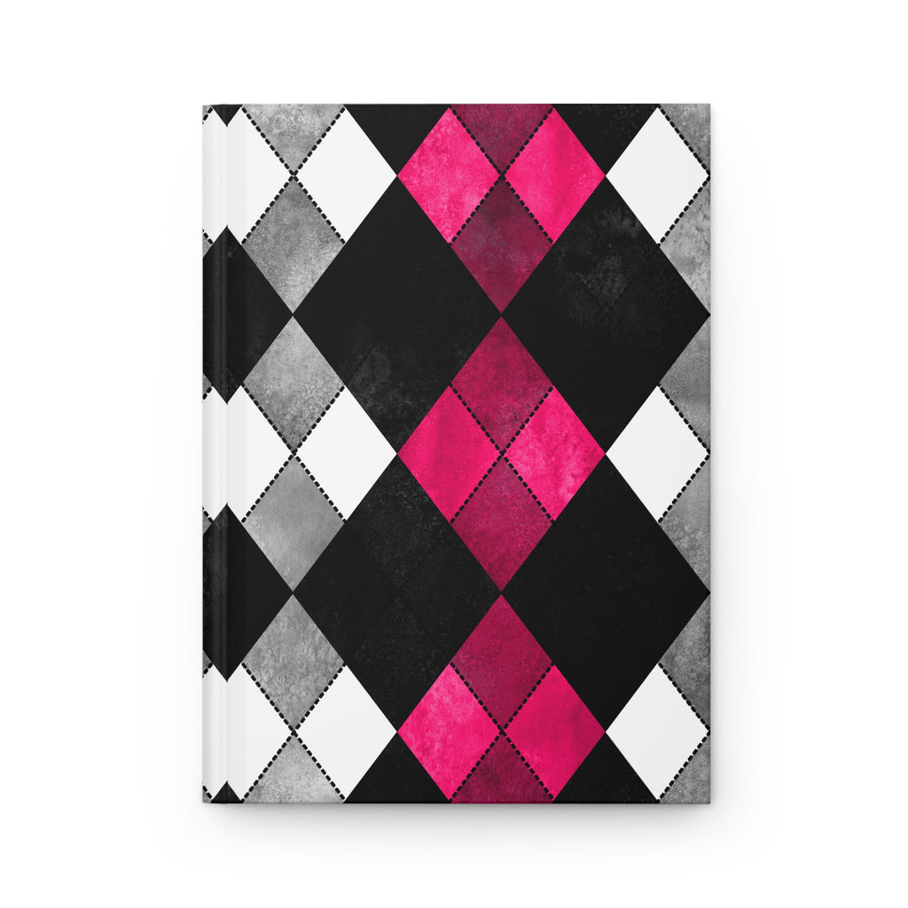 A hardcover notebook with a bold argyle pattern featuring black, white, and textured gray diamonds, accented by bright pink diamonds in the center, shown on a clean white background.