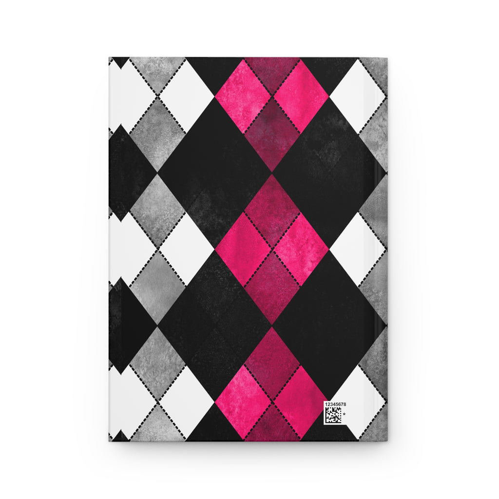 A notebook with a geometric argyle pattern cover featuring black, white, gray, and vibrant pink diamonds, shown on a plain white background.