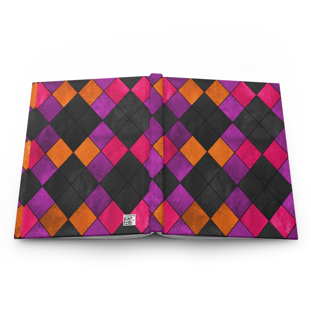 An open notebook or journal displaying a vibrant harlequin diamond pattern in black, magenta pink, purple, and orange on a clean white background.