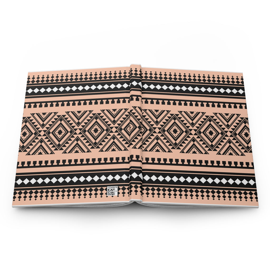 An open hardcover book showcasing a detailed geometric tribal pattern in black and white on a warm peach-beige background, photographed from directly above on a white background.