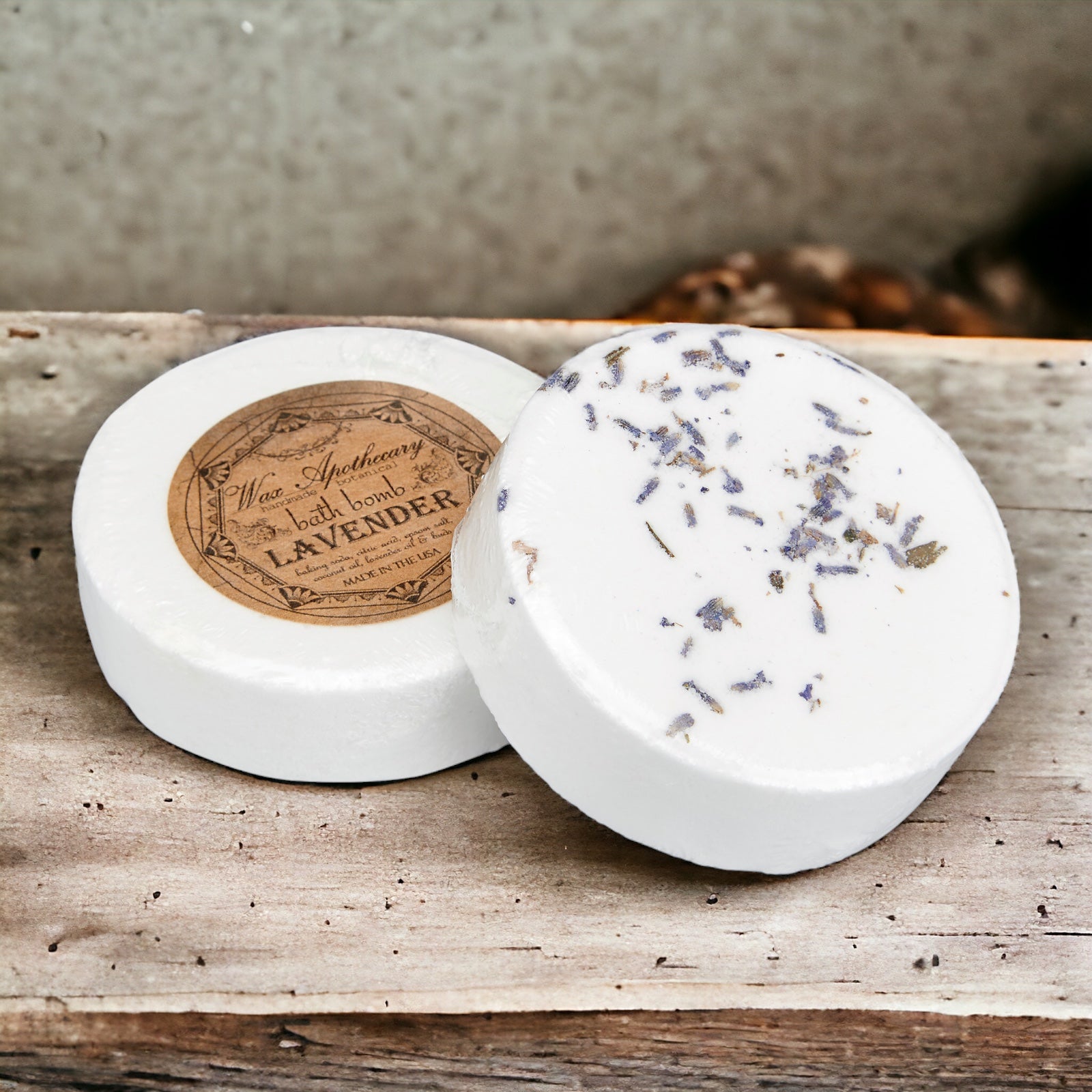 Two round bath bombs with lavender label on a wooden surface