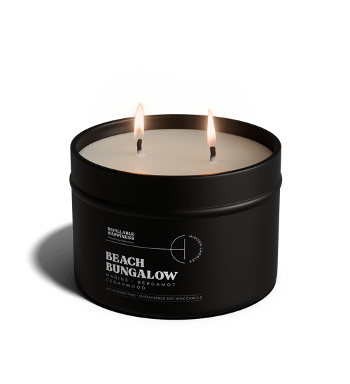 Black candle in a tin labeled 'Vineyard Estate' with a white lid on a transparent background