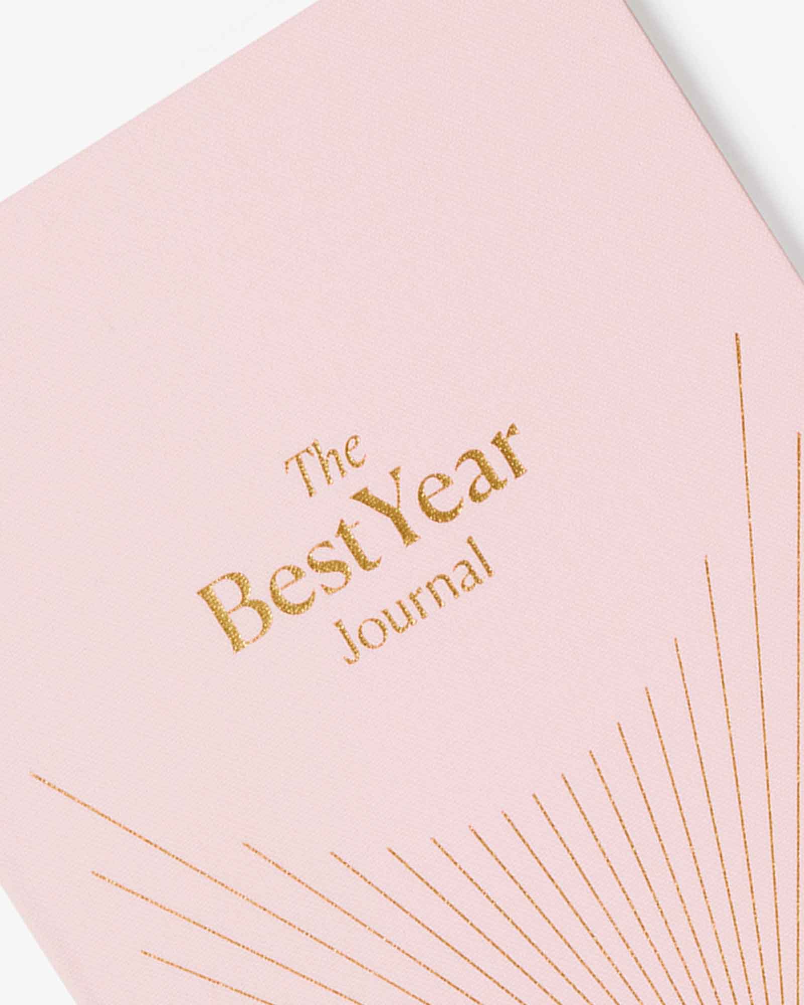Pink journal with 'The Best Year Journal' text on a light background