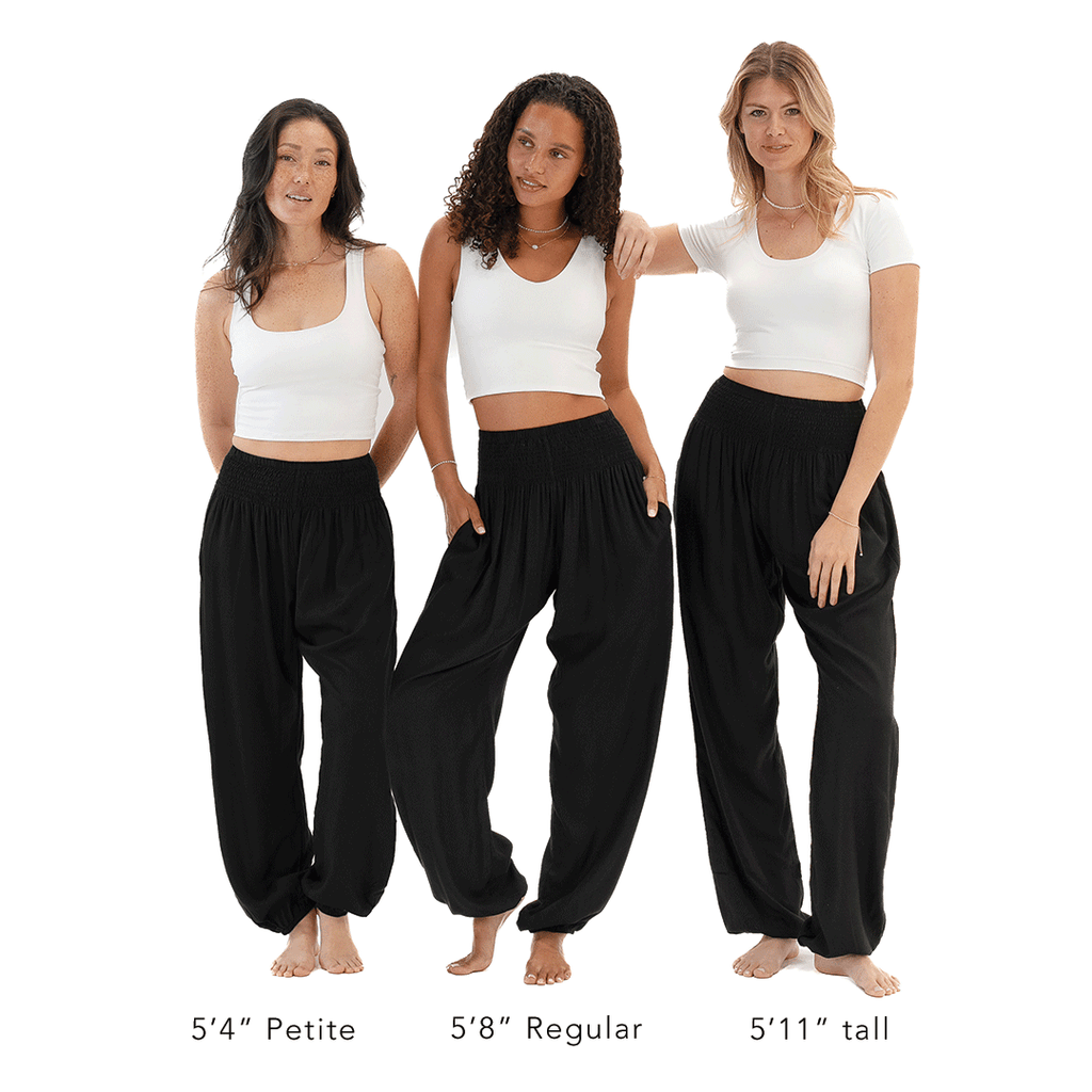 Three women wearing black pants and white tops on a white background