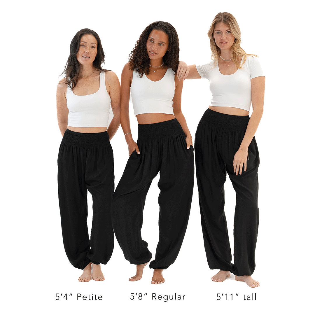 Three women wearing black pants and white tops on a white background