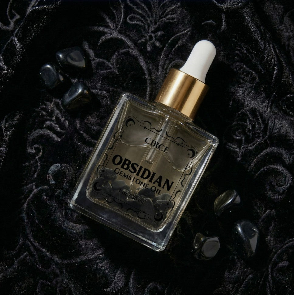 Obsidian gemstone oil bottle with dropper on a dark textured background