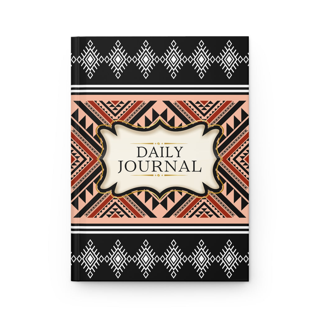 A hardcover daily journal with a geometric Southwestern-style pattern. The cover features black borders at the top and bottom with white diamond motifs, a central cream-colored label reading 'DAILY JOURNAL', and a middle band with orange, black, and beige geometric patterns.