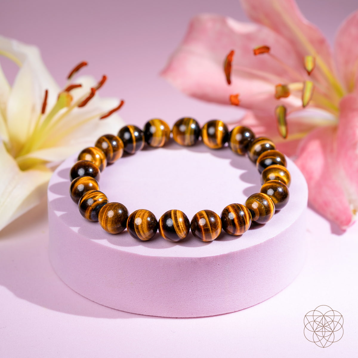 Tiger eye beaded bracelet on a pink stand with flowers in the background