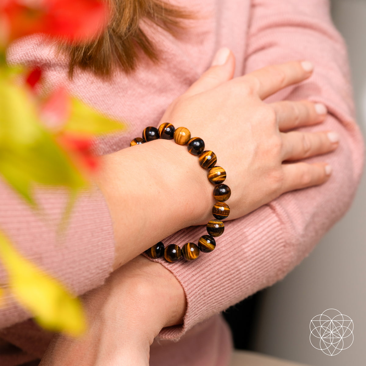 Child's hand wearing a tiger eye bracelet with a blurred background