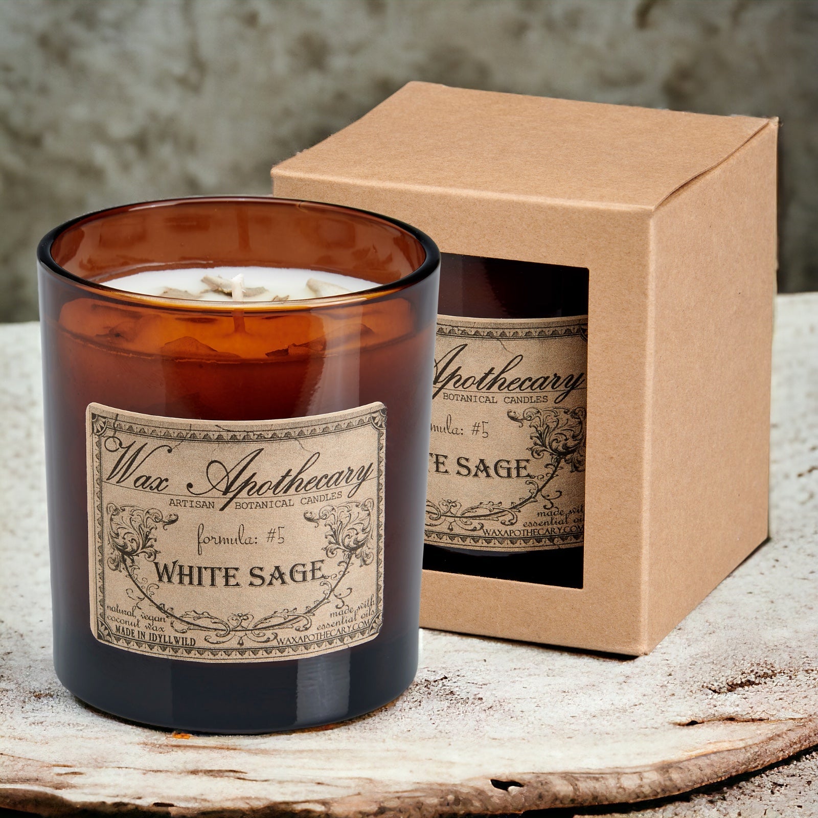 White Sage candle with an Apothecary label in front of a matching box on a wooden surface.