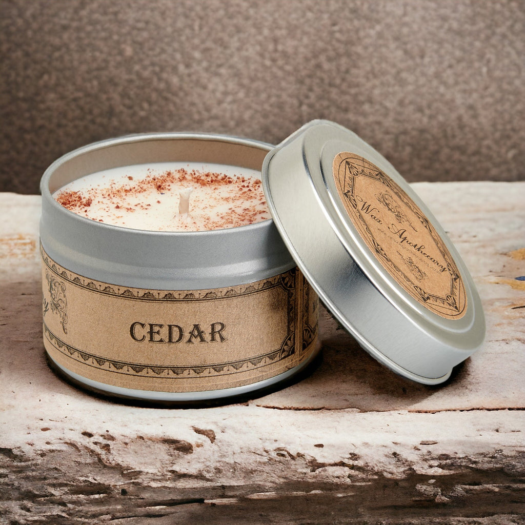 Candle in a tin labeled 'Cedar' on a wooden surface