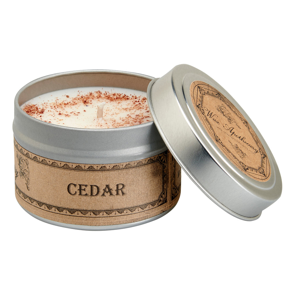 Candle in a tin labeled 'CEDAR' with a decorative lid on a white background