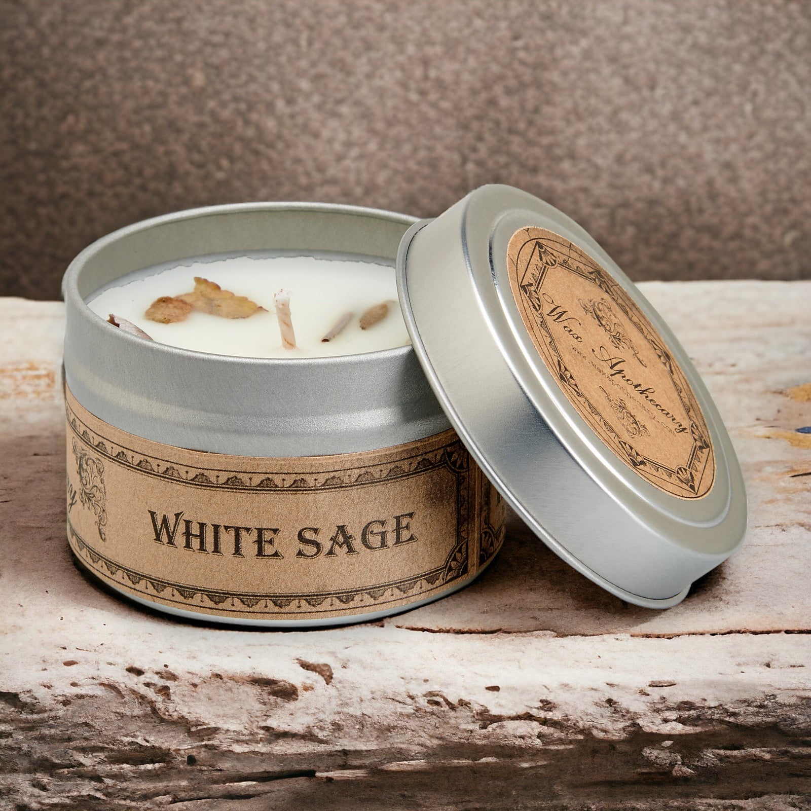White sage candle in a tin with a label on a wooden surface