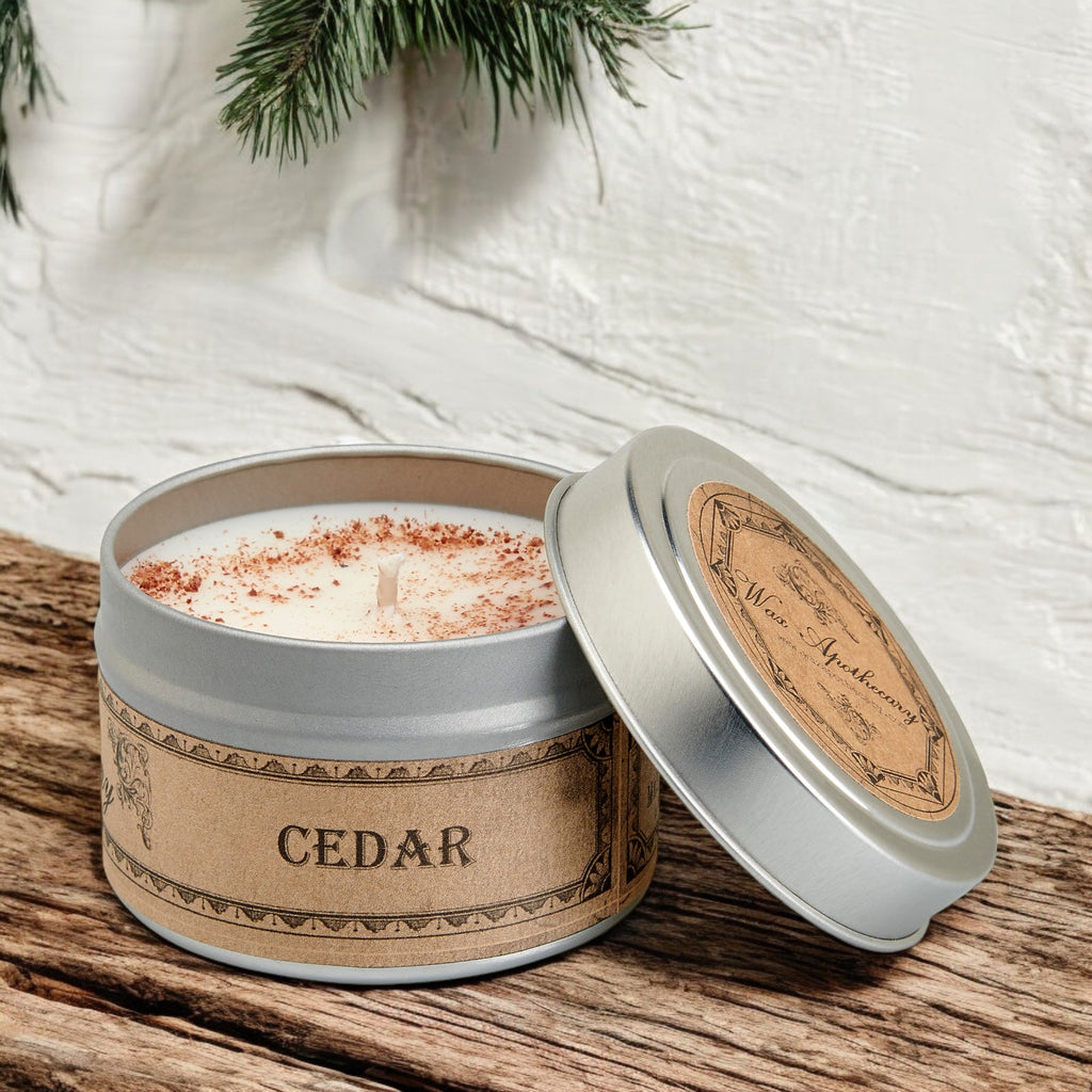 Cedar-scented candle in a tin with a wooden lid on a textured surface.