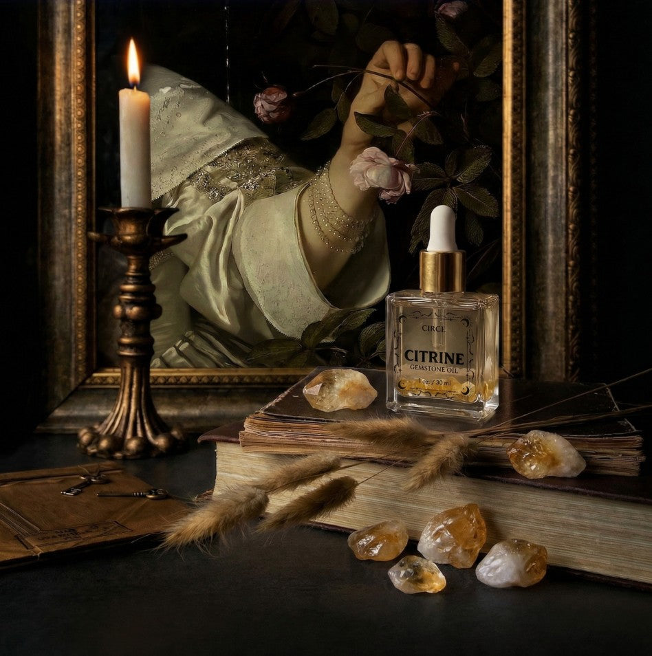 Vintage still life with a bottle labeled 'Citrine', candle, books, and crystals on a dark surface.