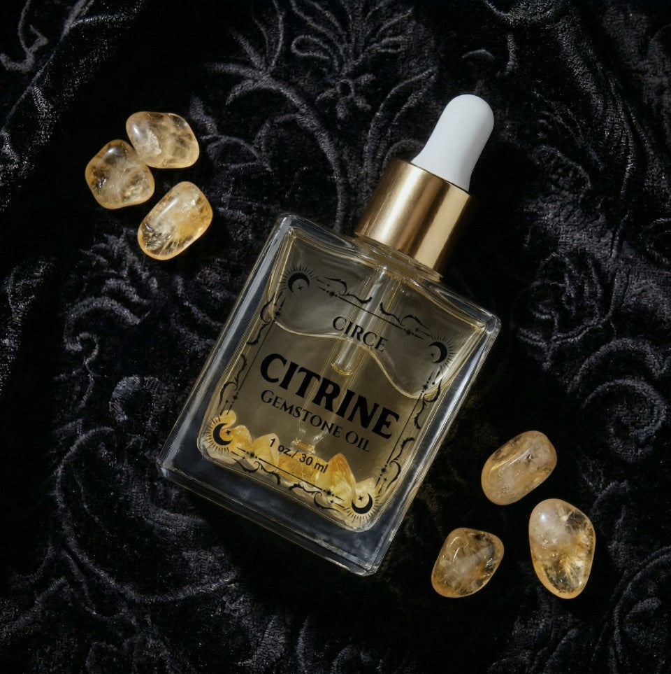Bottle of Citrine gemstone oil with crystals on a dark textured background