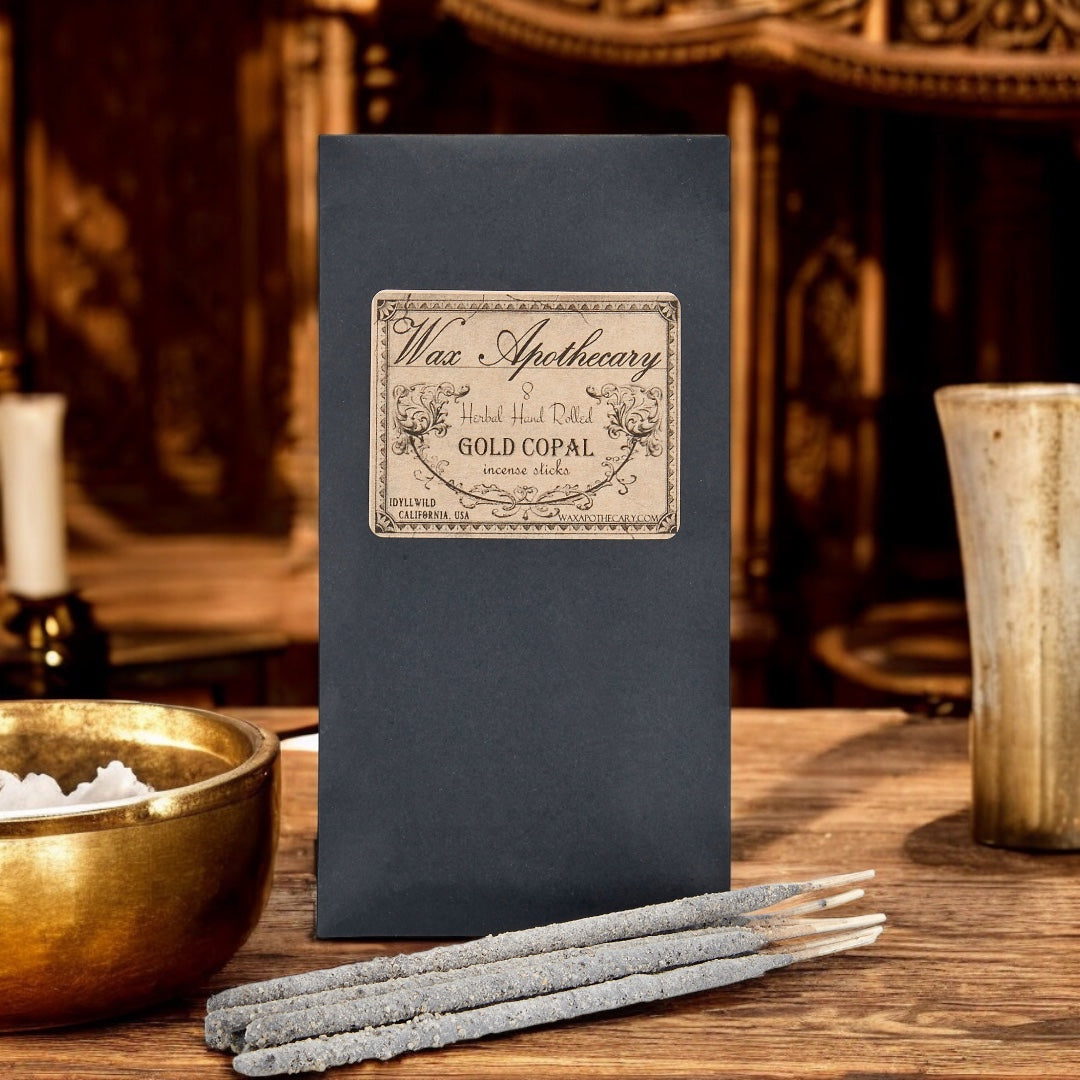 Incense sticks with a black box labeled 'Wax Apothecary' on a wooden surface.