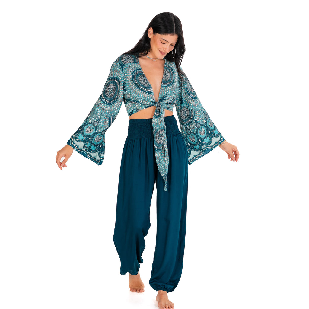Woman wearing a blue and green patterned outfit on a white background