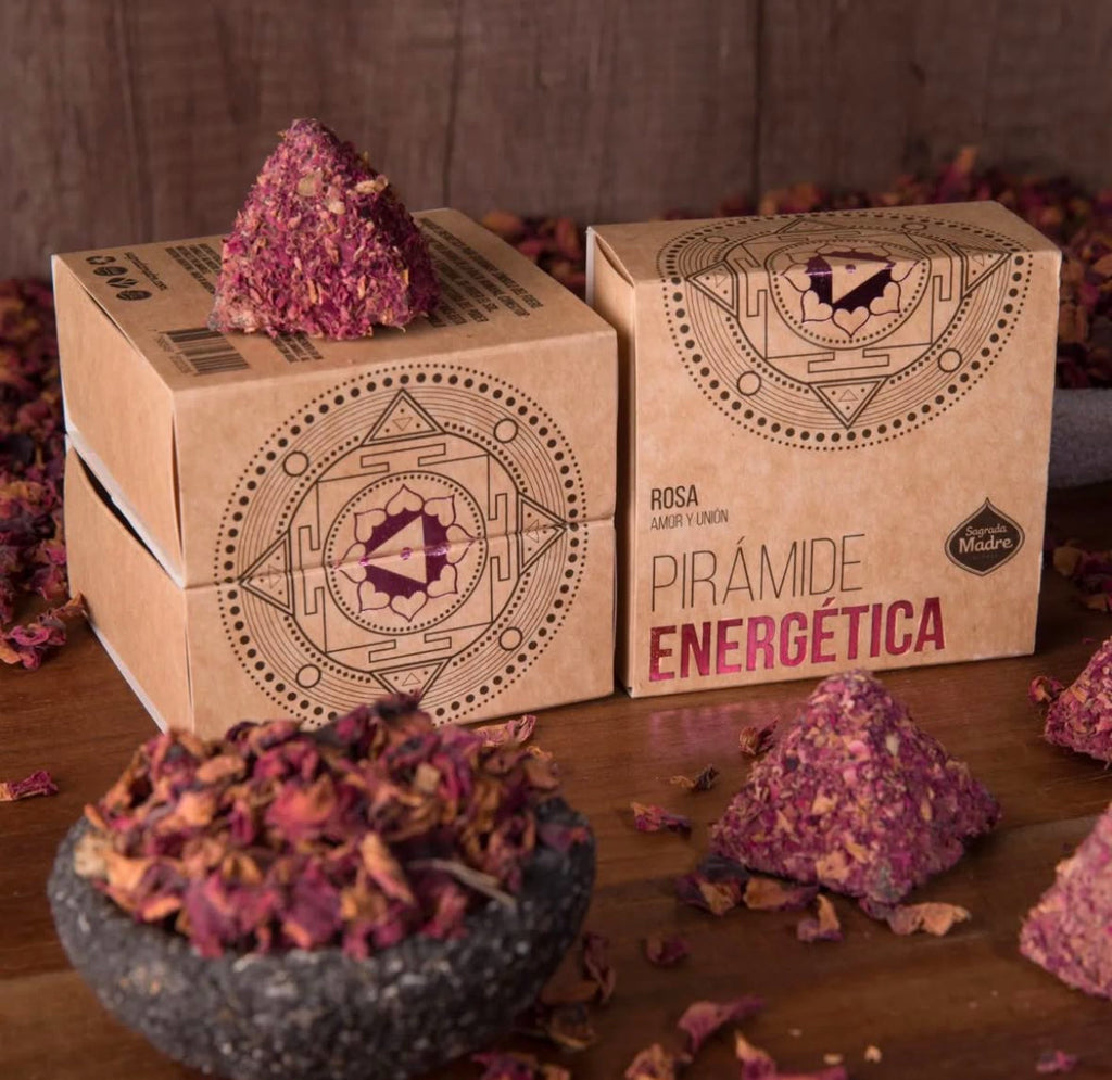 Pyramidal energy crystal packaging with decorative elements on a wooden surface.