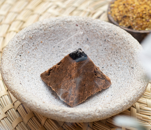 Brown square incense stick on a stone surface with a blurred background