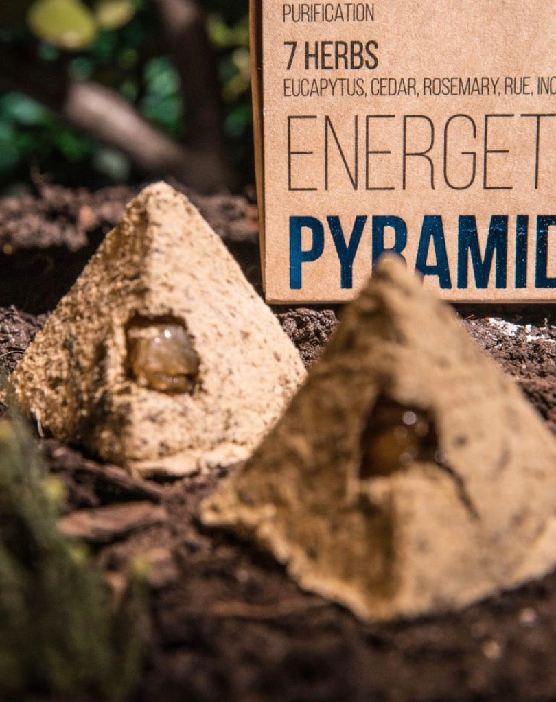 Two energy pyramids with a sign indicating '7 Herbs' on a natural background