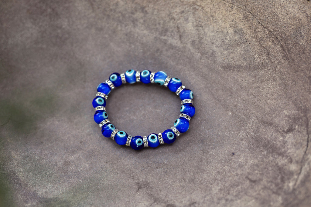 Blue beaded bracelet on a gray stone surface