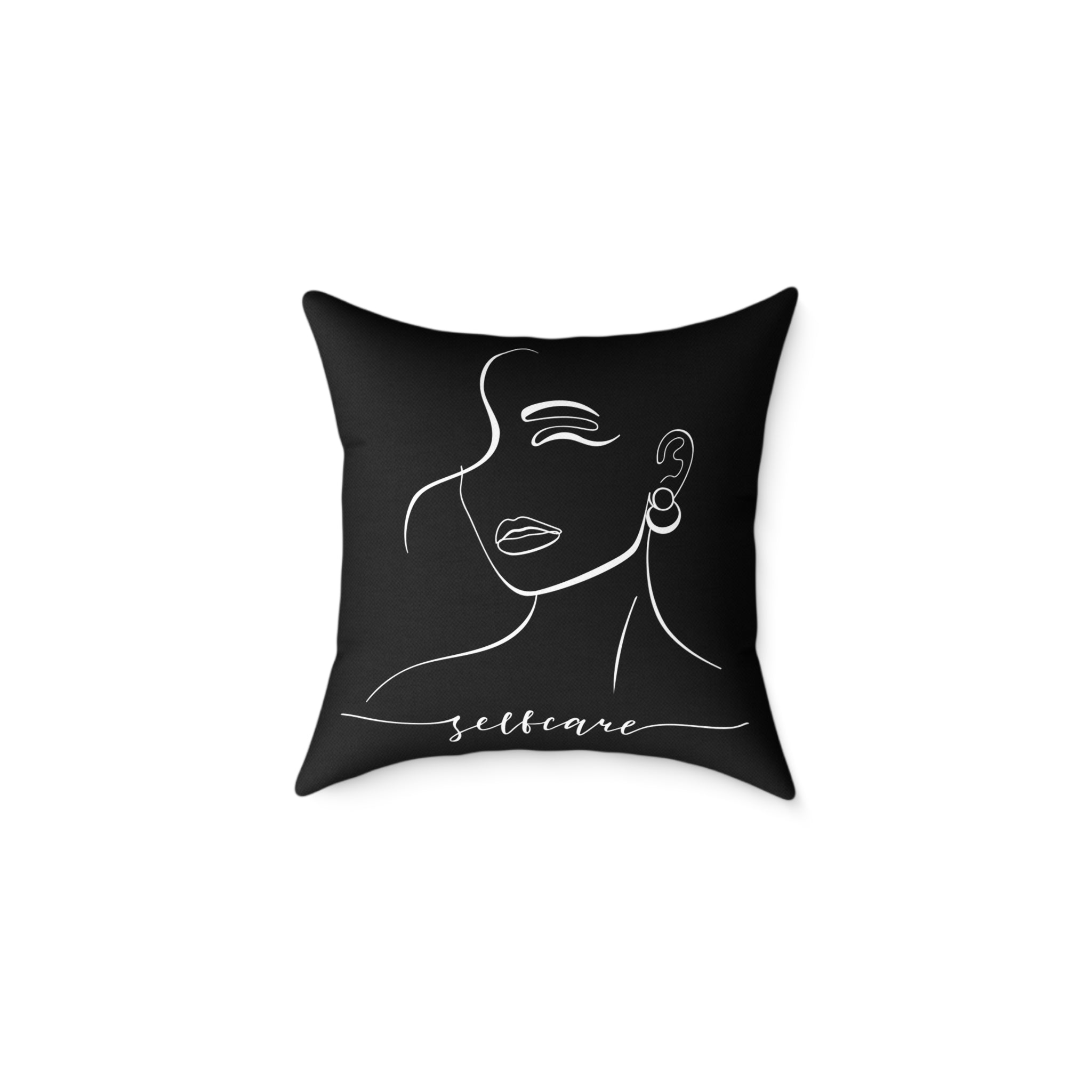 Black pillow with a white line drawing of a woman's face and the word 'selfcare' on a white background