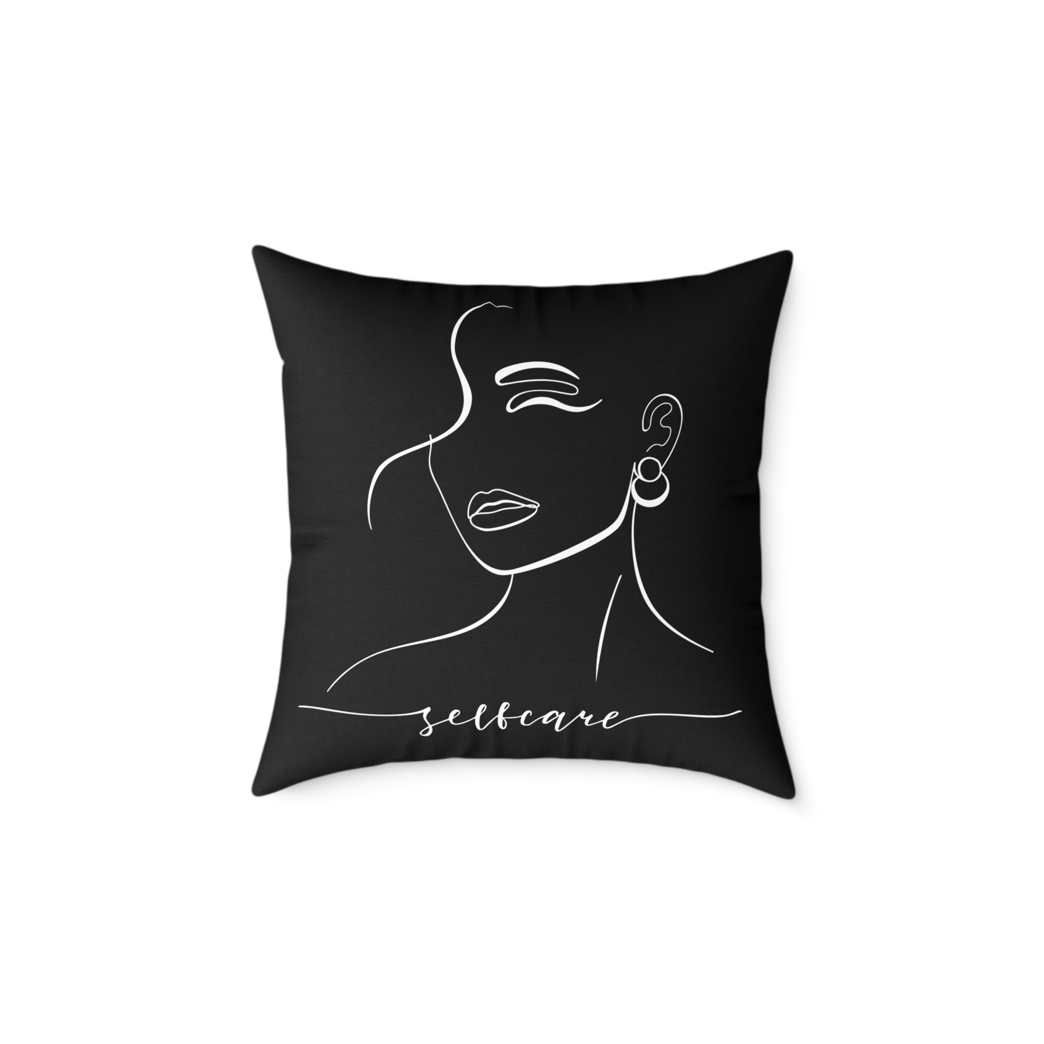 Black pillow with white line art of a woman's face and 'selfcare' text on a white background