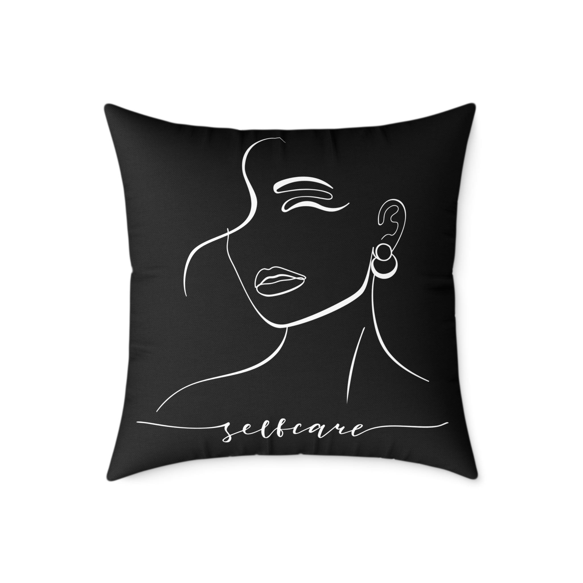 Black pillow with white line art of a face and 'selfcare' text on a white background