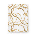 A hardcover notebook with a white cover decorated with a repeating pattern of interwoven gold chains and pearl-like beads, shown against a plain white background.