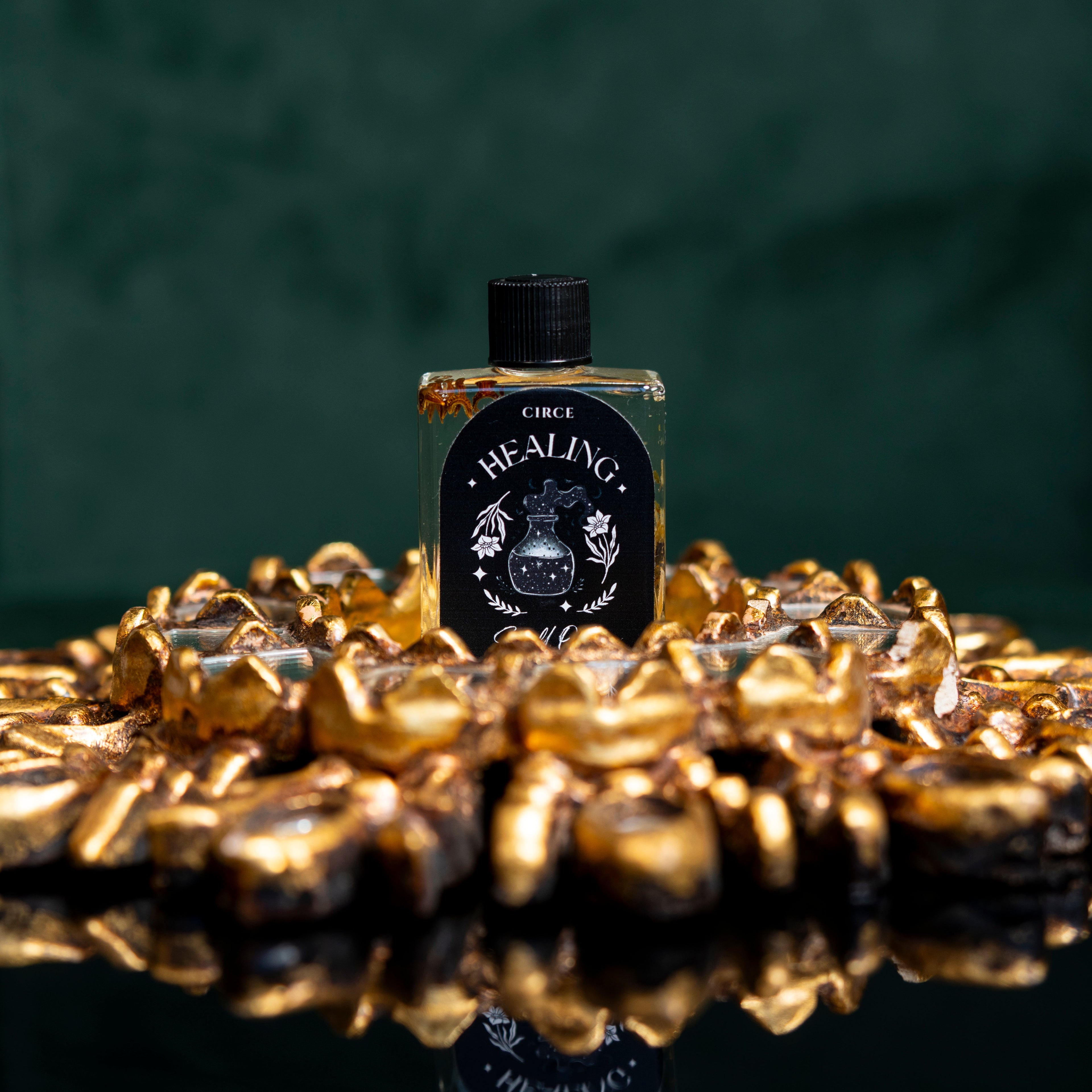 Bottle labeled 'Healing' on a decorative surface with a dark green background