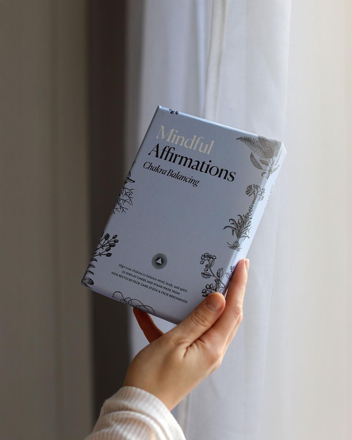 Book titled 'Mindful Affirmations' held by a hand against a neutral background