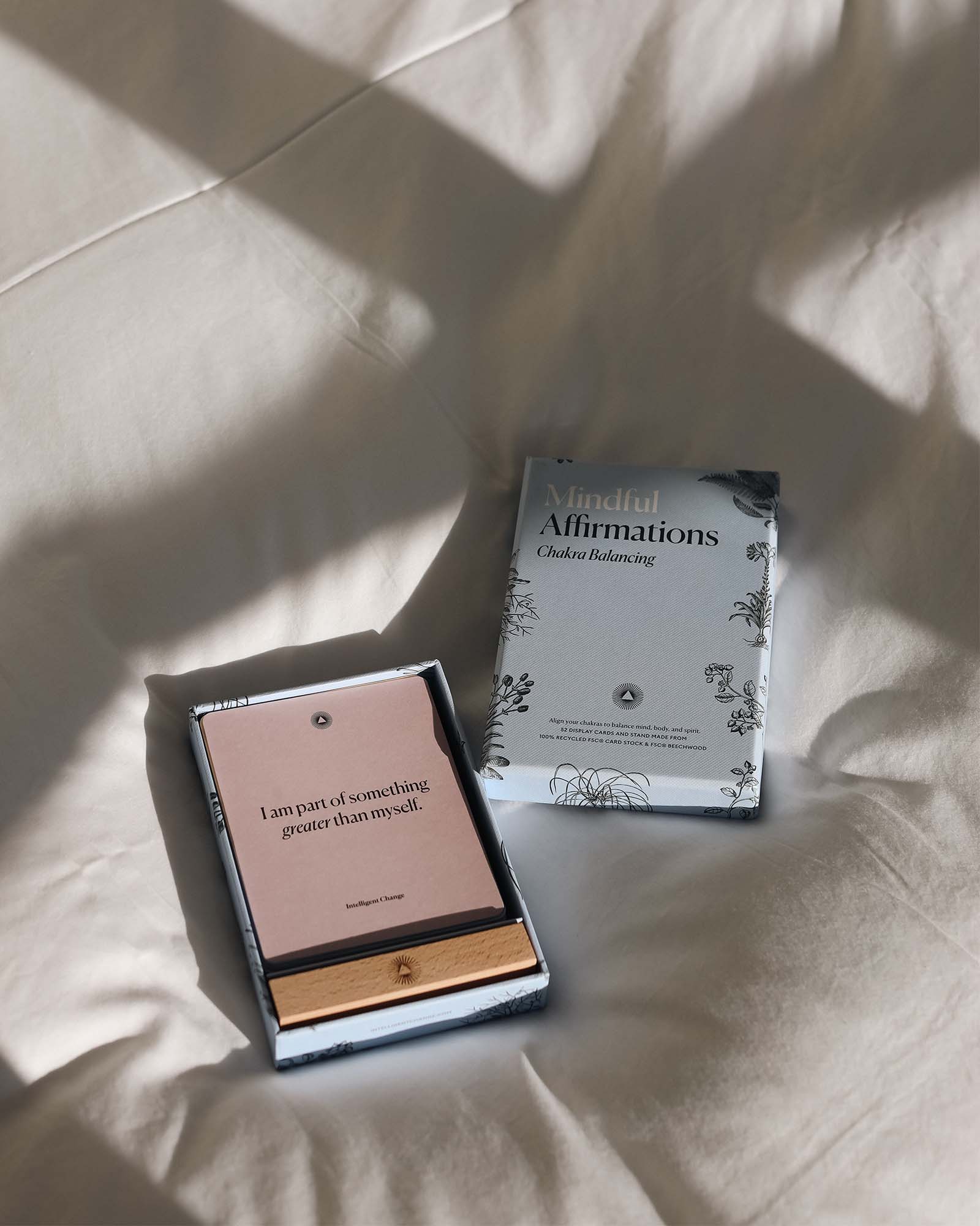 Two books on a textured surface with soft shadows