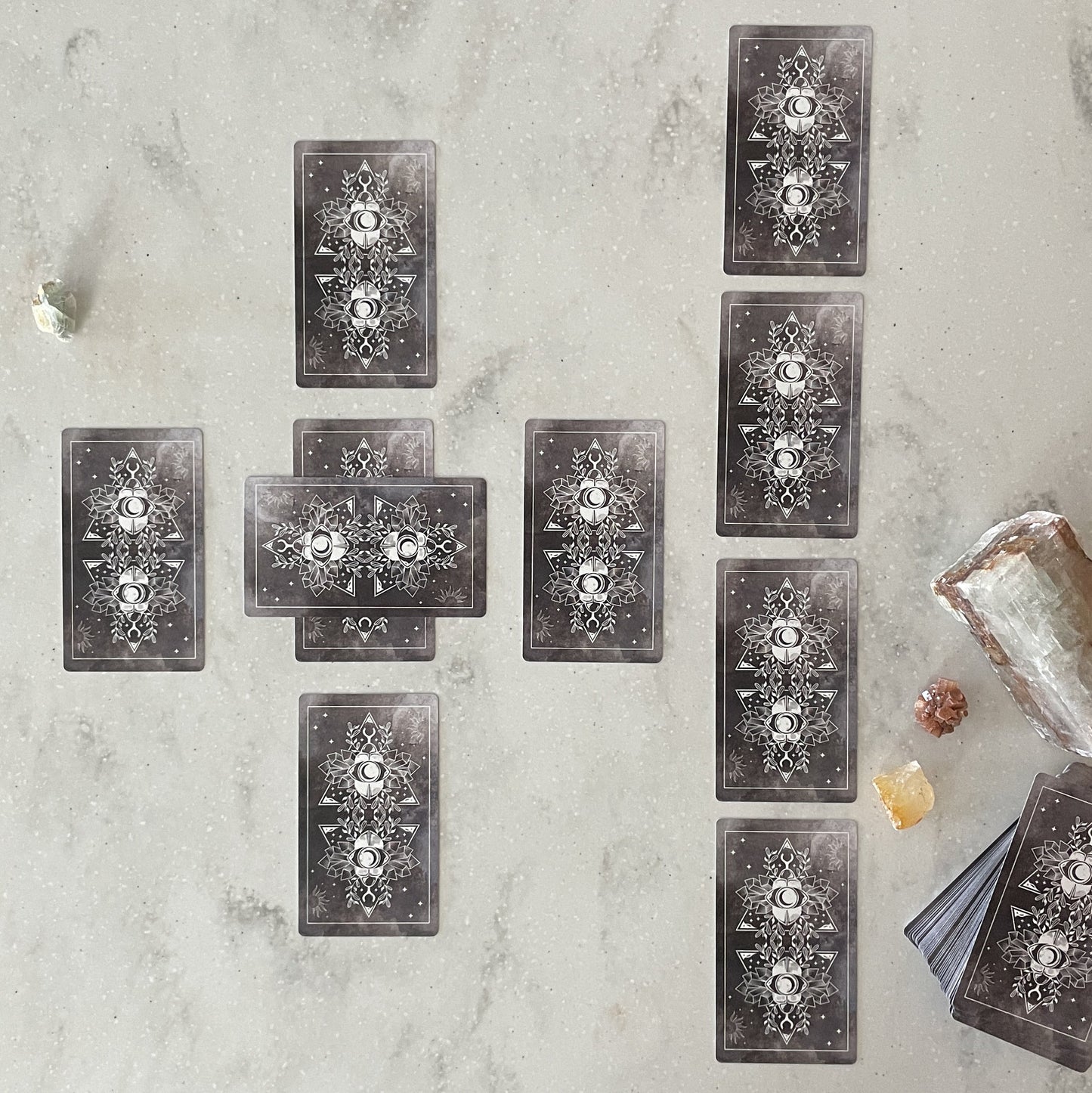 Set of tarot cards on a textured surface with crystals and a crystal ball.