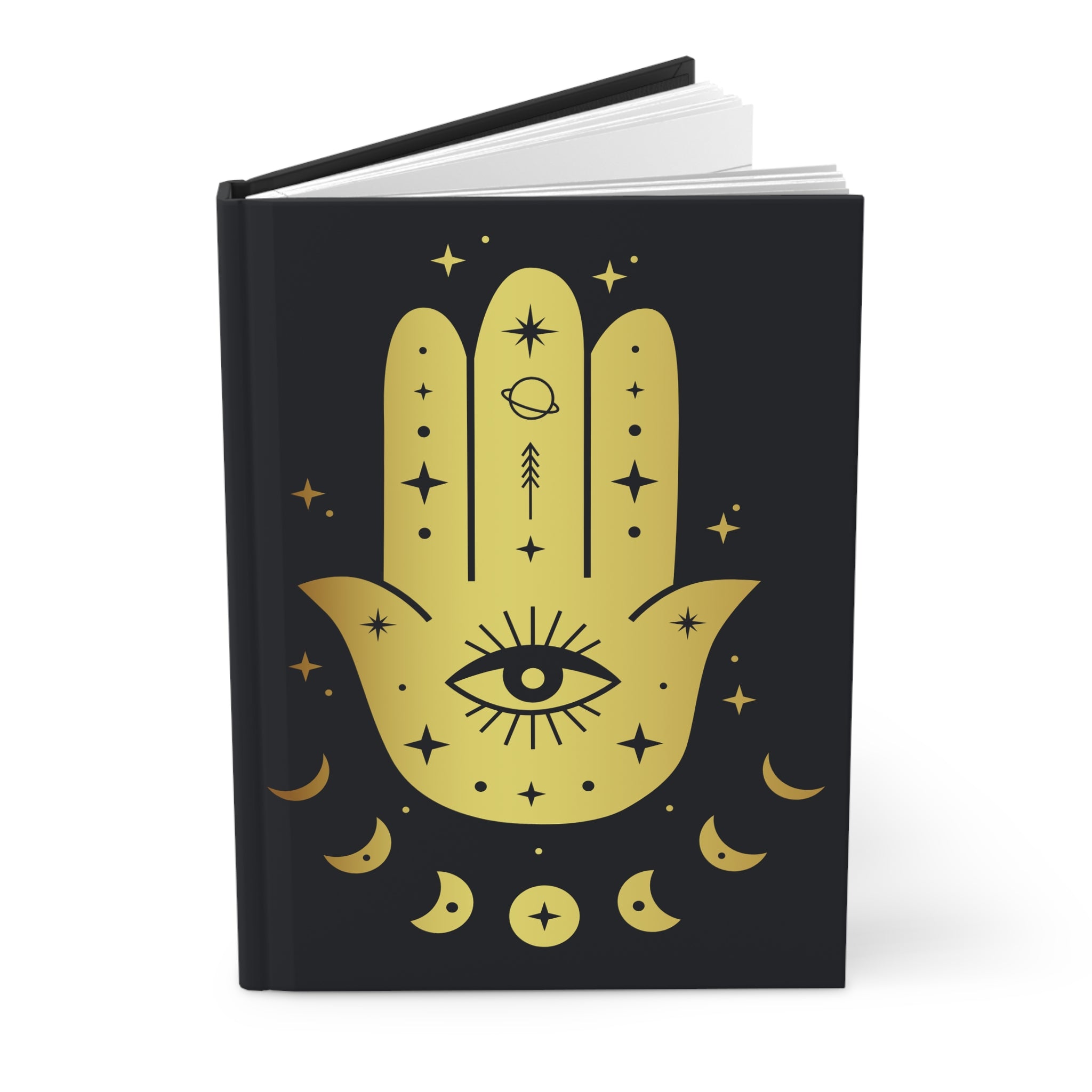 A hardcover notebook with a black cover featuring a large gold Hamsa hand illustration decorated with stars, crescent moons, and an eye of providence, shown on a white background.