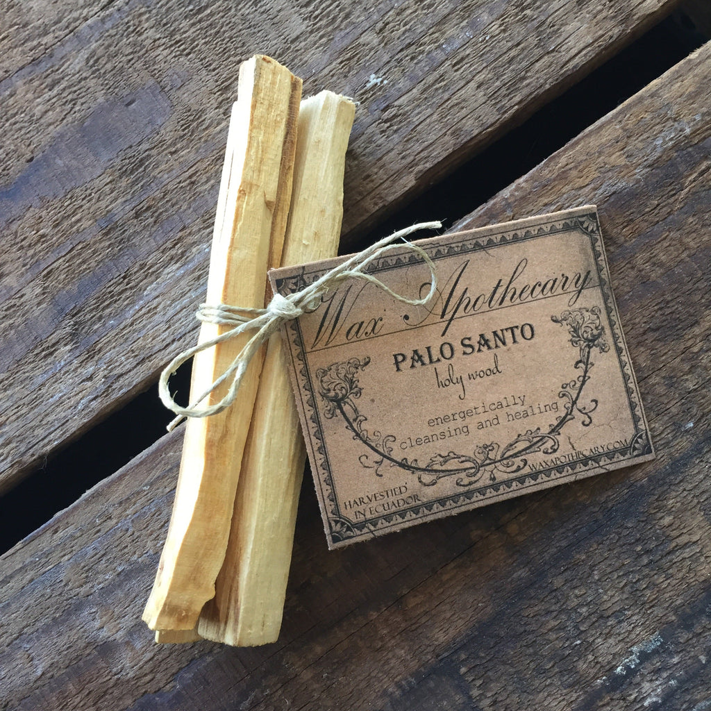 Palo Santo sticks tied with twine on a wooden surface with a label.