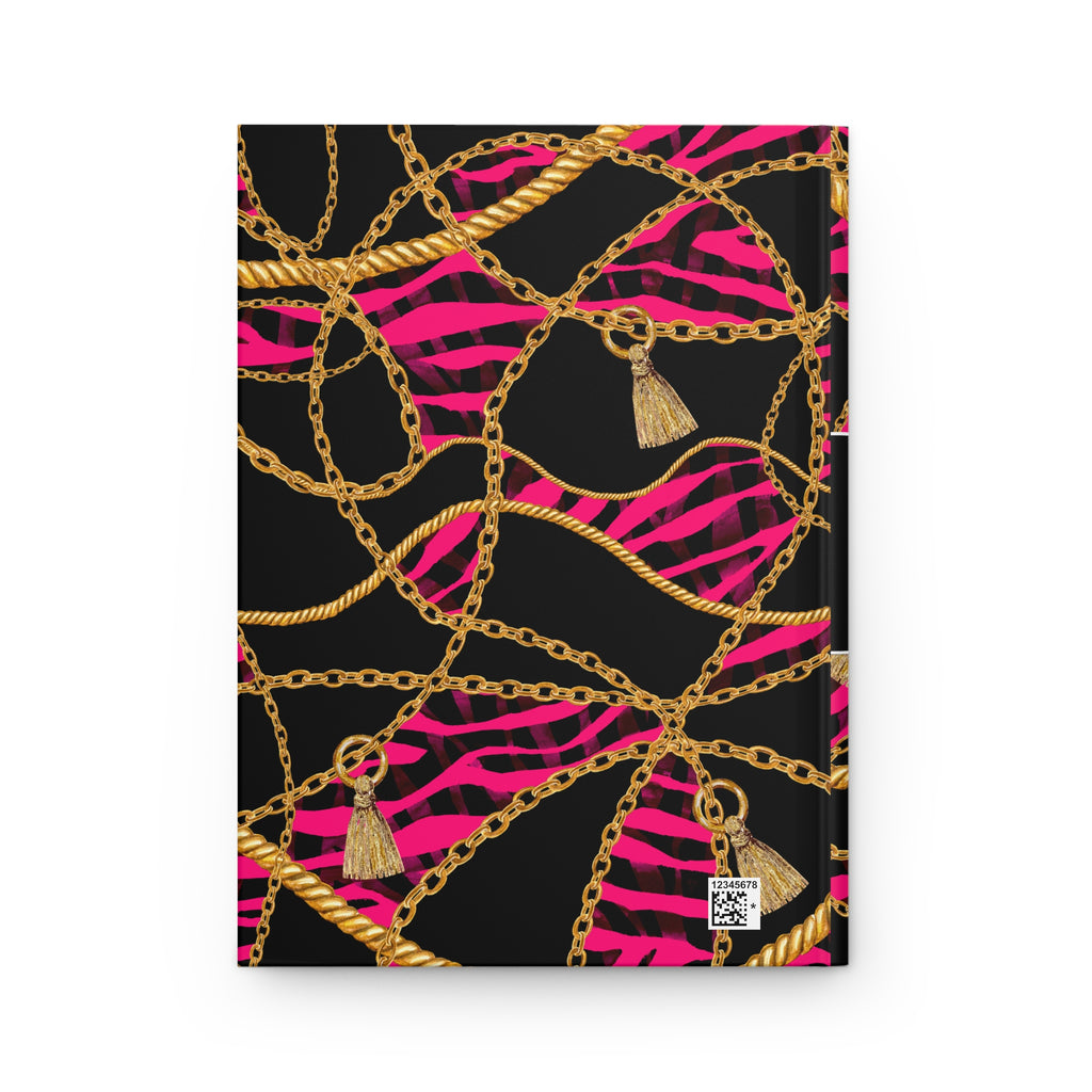 A hardcover notebook with a bold pattern featuring gold chains, gold tassels, and hot pink zebra stripes on a black background, shown against a plain white backdrop.
