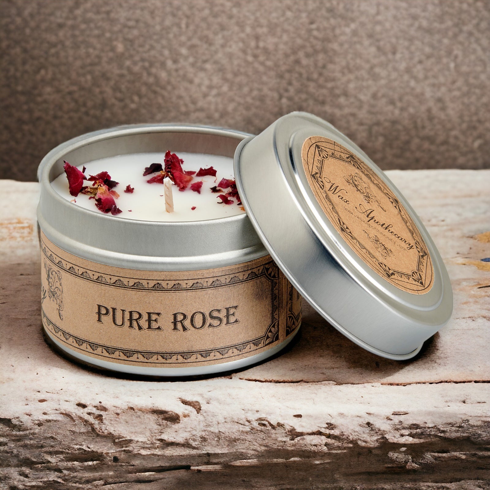 Candle in a tin labeled 'Pure Rose' on a wooden surface