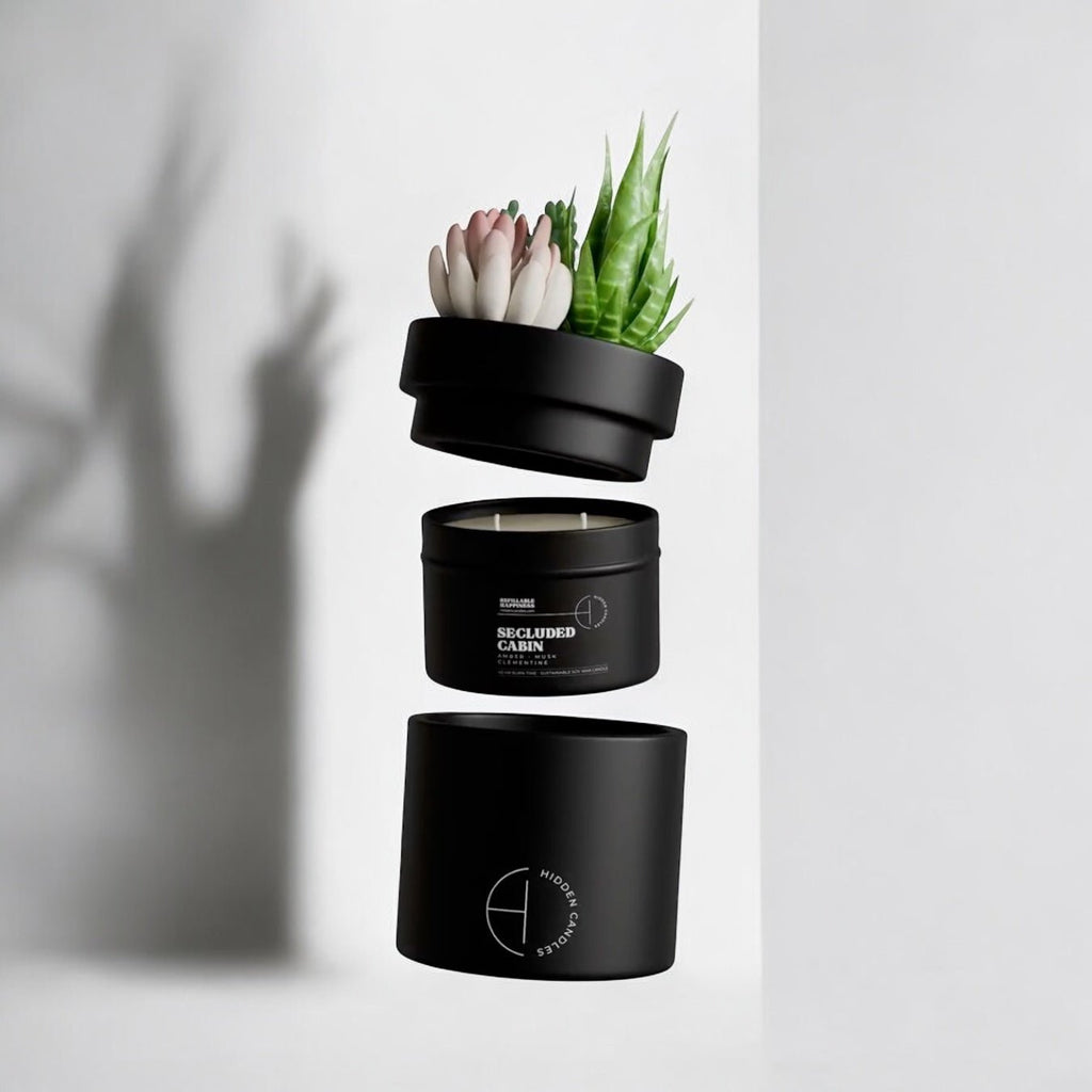 Black candle container with succulents on a white background