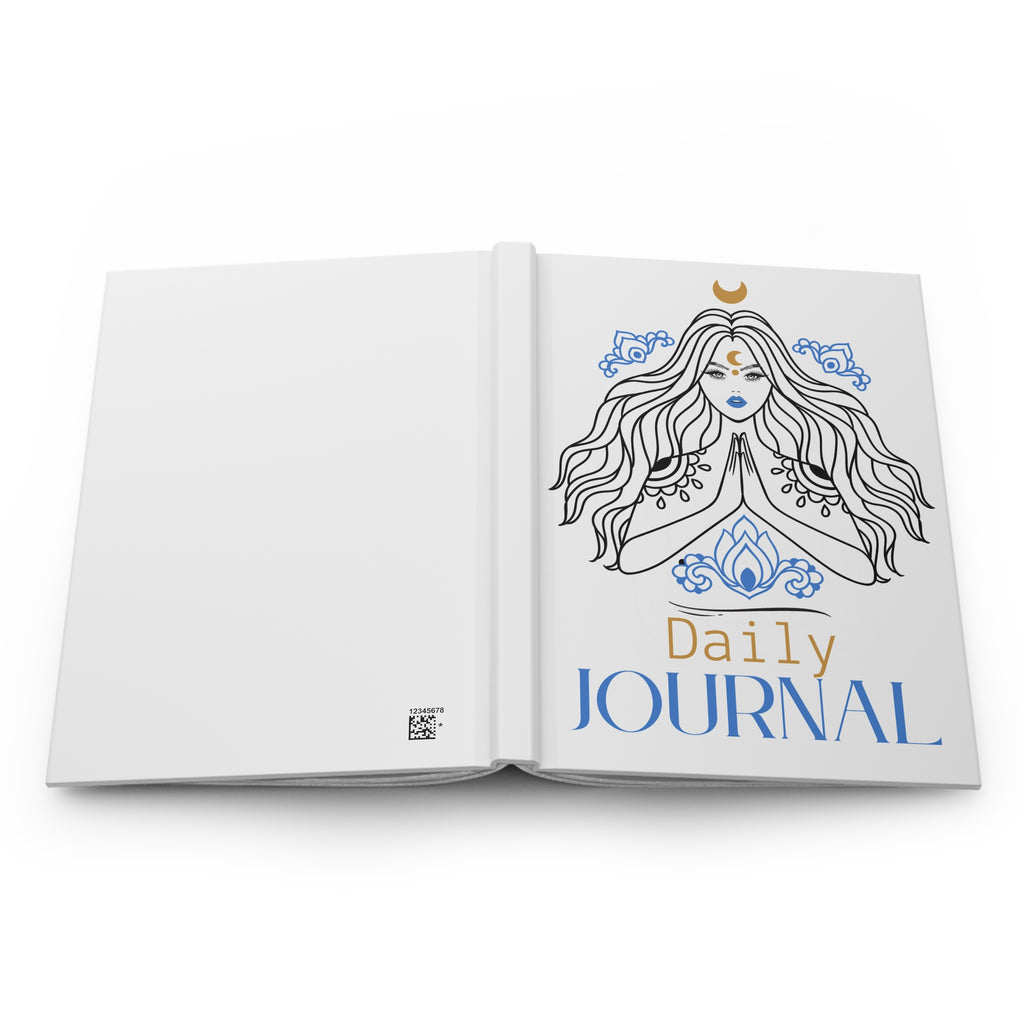An open white hardcover daily journal shown from the front, featuring a line-art illustration of a meditating woman with blue and gold details and the text 'Daily JOURNAL' on the right page.
