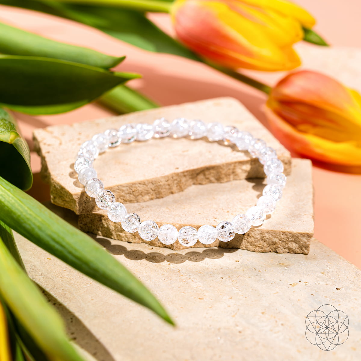 Crystal bracelet on a stone with tulips in the background